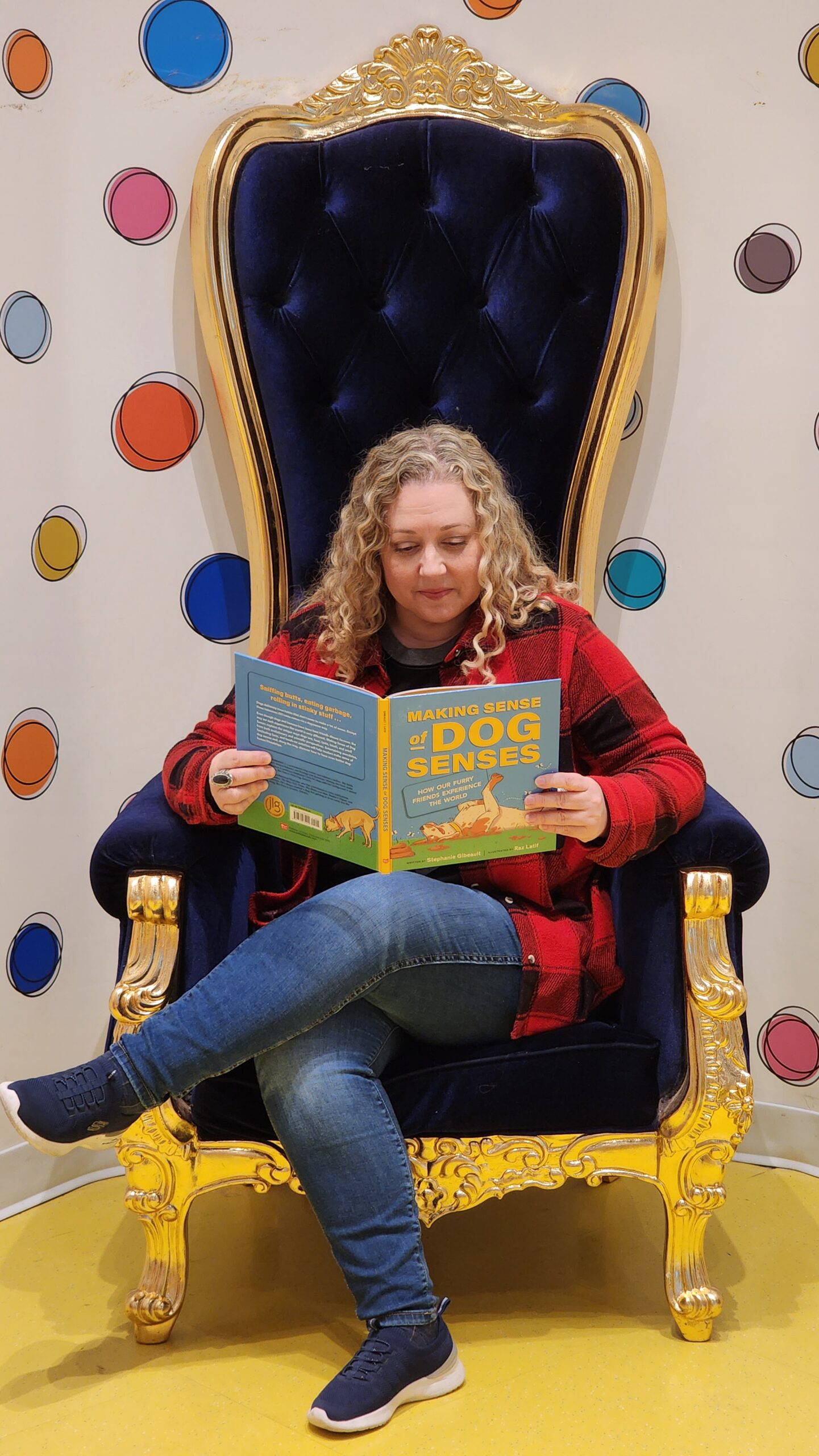 Stephanie Gibeault reading her book in a large chair